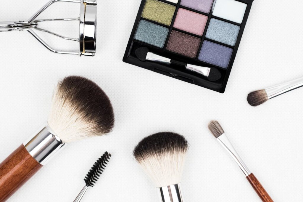 pexels-photo-208052 Top view of makeup tools and a colorful eyeshadow palette arranged artistically.